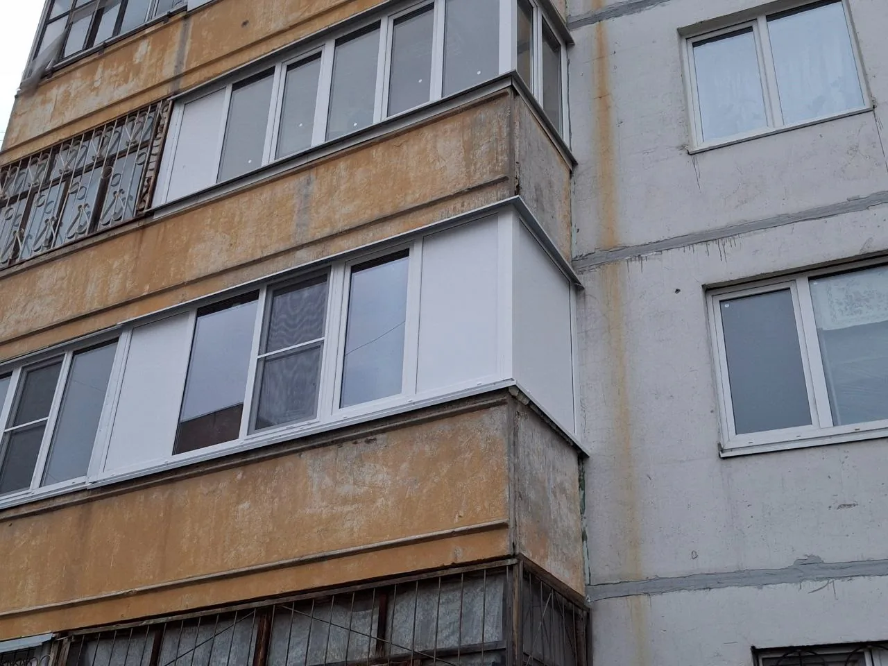 Фасад панельного дома с новыми пластиковыми окнами
